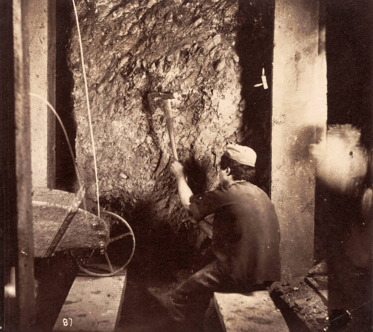 A Comstock miner drilling into the rock face underground, Virginia City